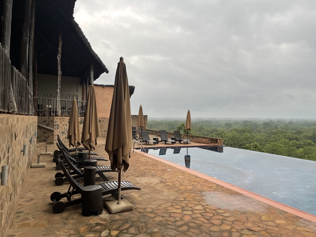       Chairs and umbrellas by an infinity pool.
  