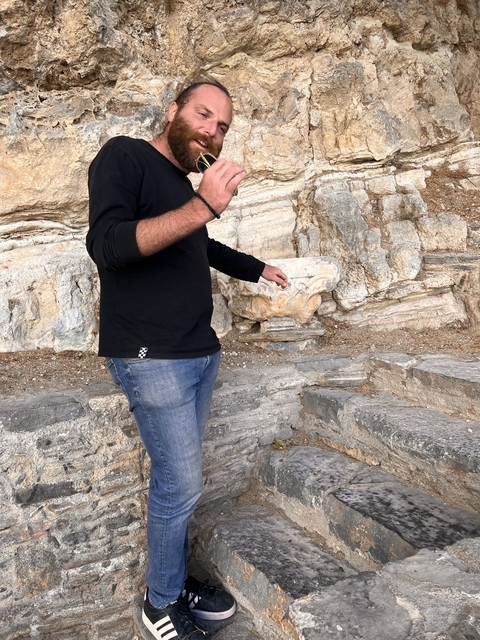       Person standing on stone steps with a carved stone element.
  