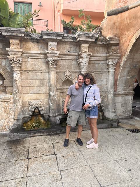 Couple posing by an ornate fountain.