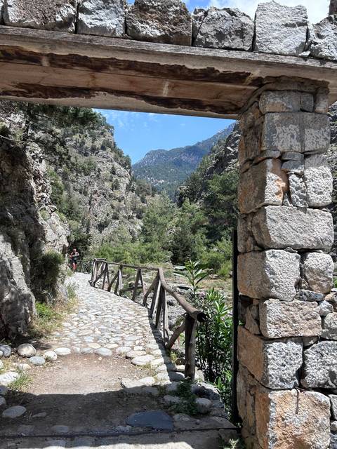 Stone archway overlooking a mountain landscape.