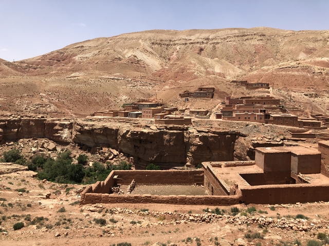       Rustic village in a rocky landscape under a clear sky.
  