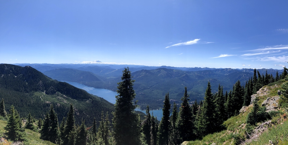       Panoramic view of a mountainous region with a lake.
  
