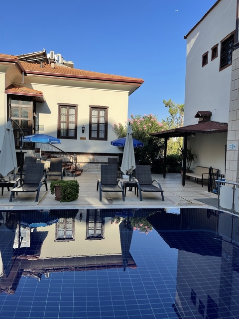       Outdoor swimming pool area with lounge chairs and umbrellas.
  