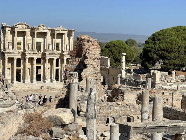       Ruins of an ancient city with tourists exploring.
  