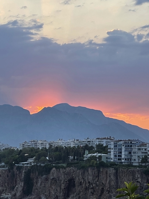       Sunset view with mountains and vibrant clouds.
  