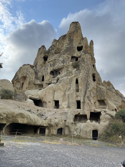       Ancient rock-cut dwellings in a large rock formation.
  