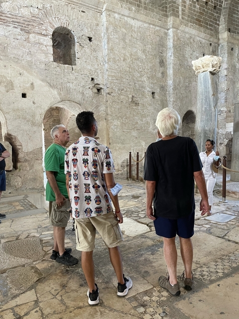       Tourists observing an interior section of an ancient structure.
  