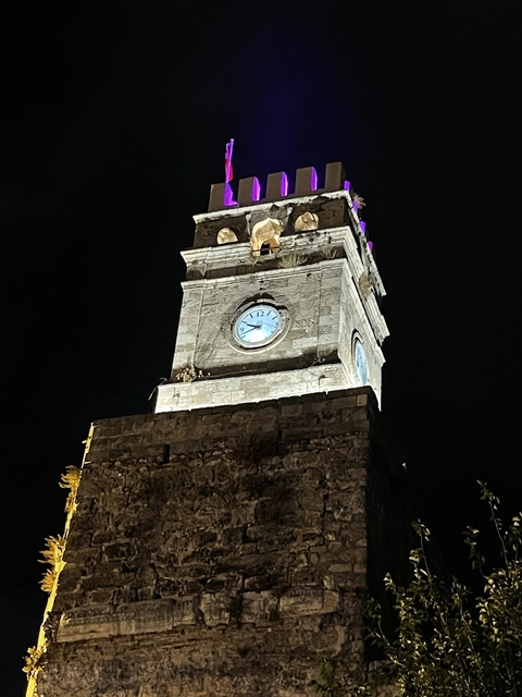       Illuminated clock tower at night.
  