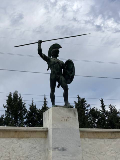 A statue of an ancient warrior holding a spear and shield.