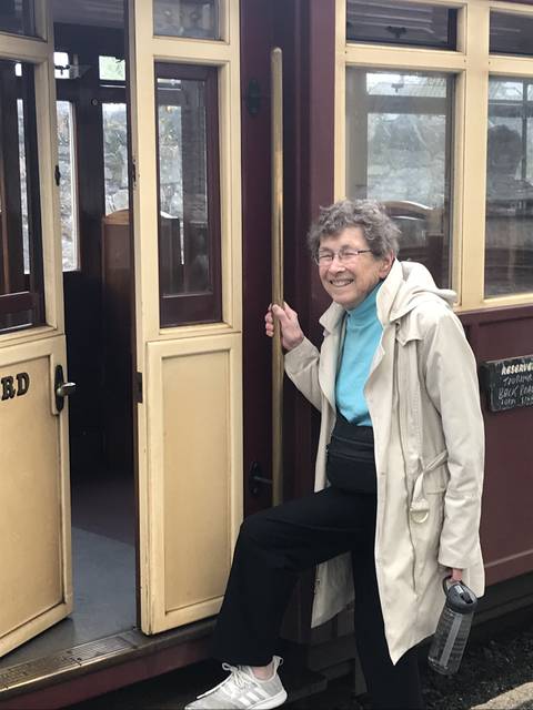       A woman posing on a vintage train car.
  