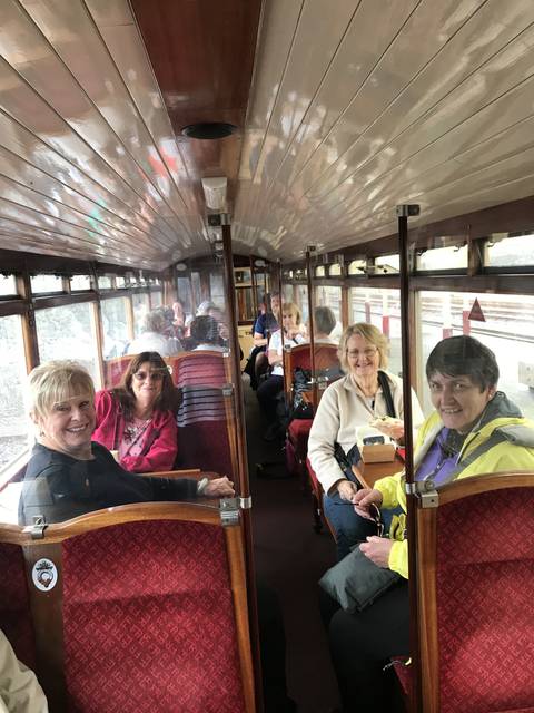 People sitting in a vintage train compartment.
