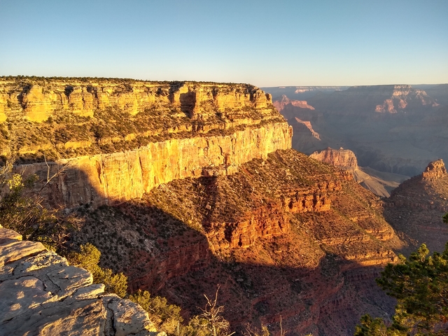Panoramic view of Grand Canyon National Park at sunset, showcasing its vastness.