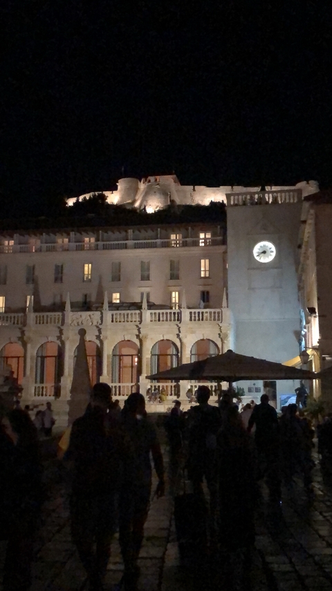       City clock tower at night with subdued lighting.
  