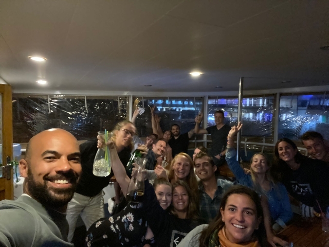      Group of people partying inside a boat or a bar at night.
  