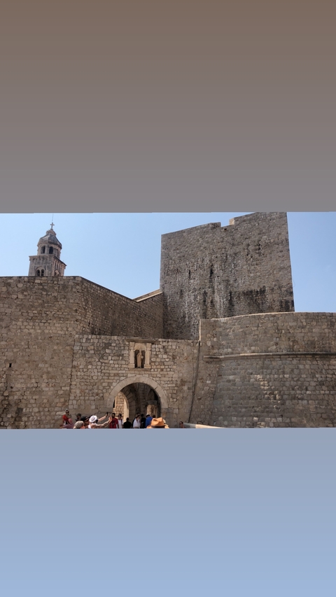       Ancient stone fortress walls with a bell tower.
  