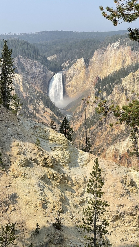       Scenic view of a waterfall in a canyon with trees framing the scene.
  