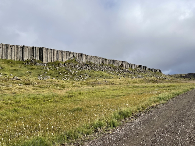       Columnar basalt formations beside a dirt road.
  