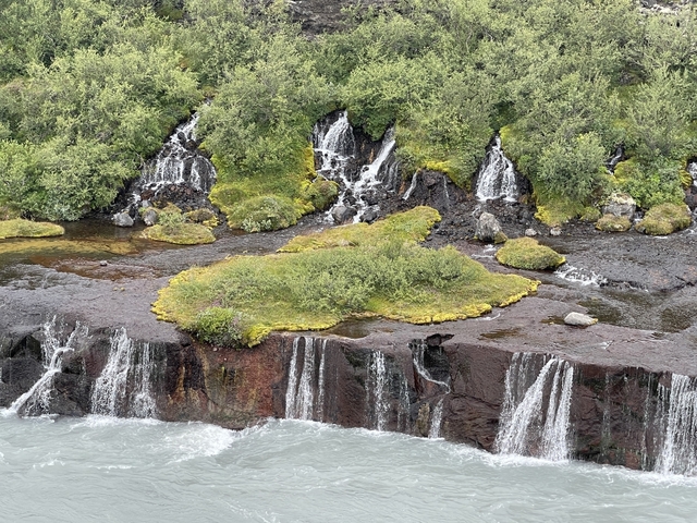       Water flowing over multiple lava rock falls.
  