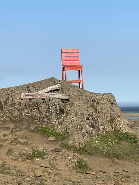       Large red chair on a rock with text visible.
  