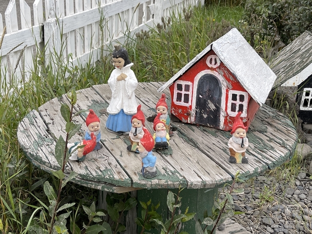       Miniature house and figurines on a wooden table.
  
