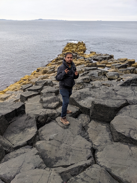       Person posing on a rocky coastal area.
  