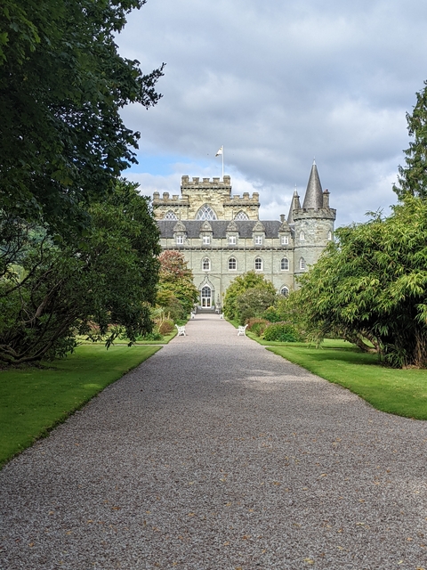 Scenic view of a historic castle with lush gardens.