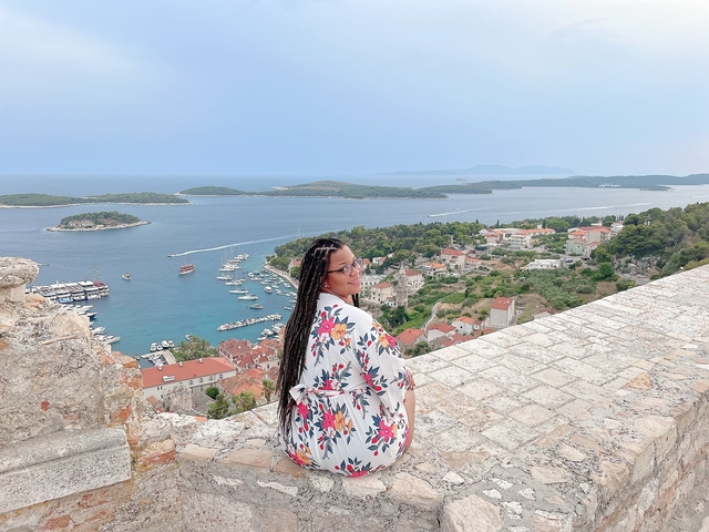 Person overlooking a coastal town and ocean view.