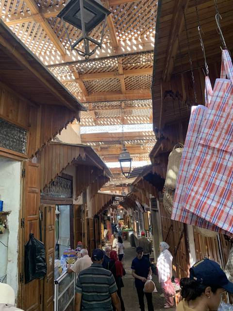 Busy market street with people and stalls.