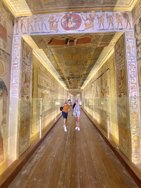       Couple standing in a corridor with Egyptian hieroglyphs.
  