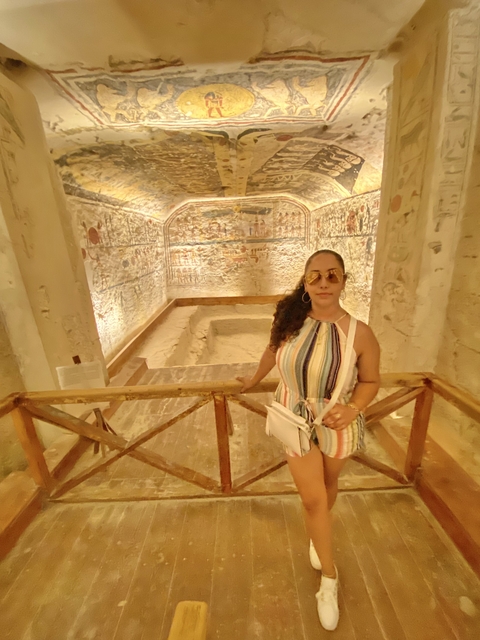       Person standing in front of a decorated stone wall.
  