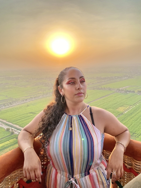       Person posing with a rural landscape at sunset.
  