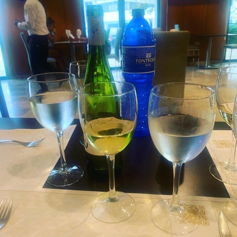 Table with several glasses of white wine.