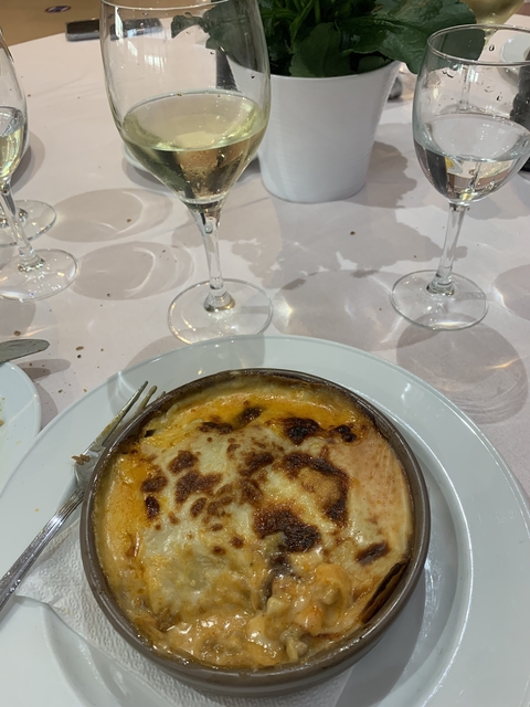 Dish of baked cheese with wine glasses.