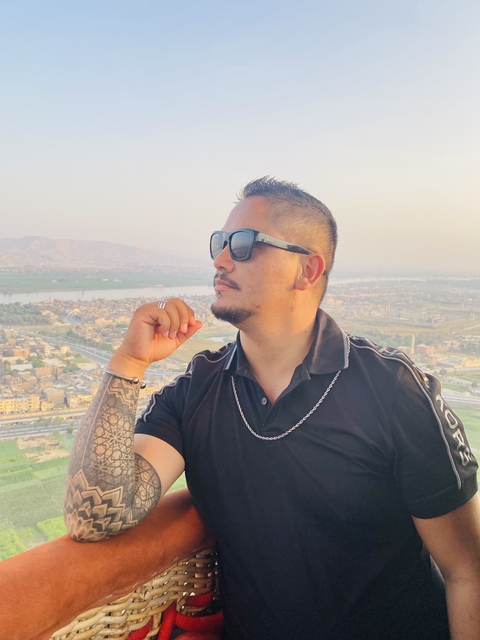       Man enjoying a high vantage view of a city and river.
  