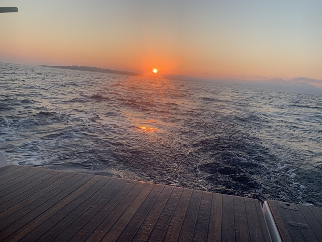 Sunset over the ocean viewed from a boat.