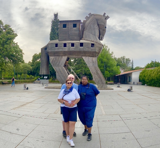       People posing in front of the Trojan Horse structure.
  