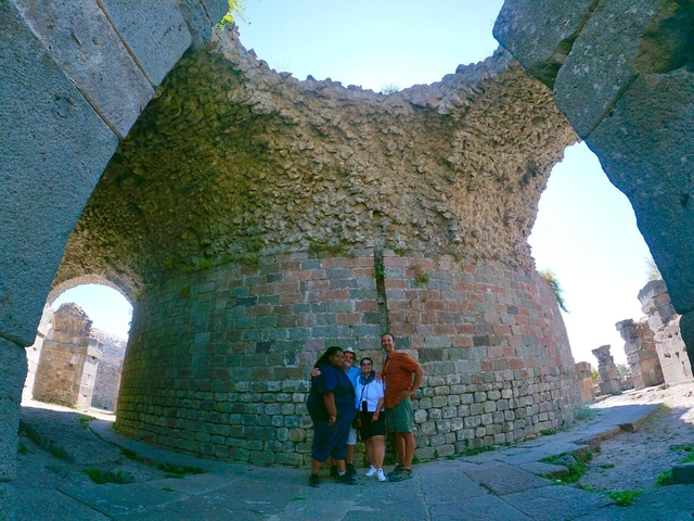       Group of people standing inside ancient ruins.
  