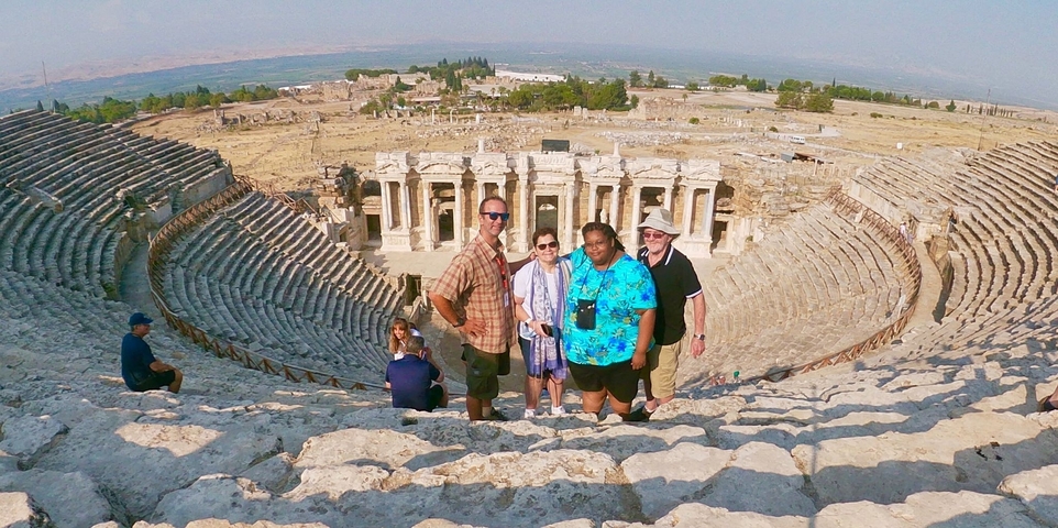       Group of people at an ancient amphitheater.
  