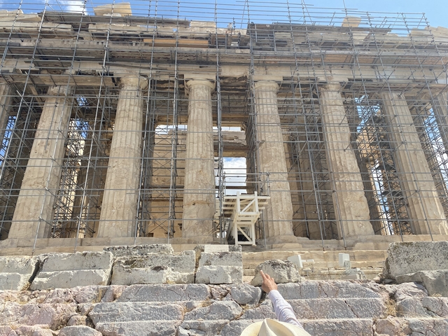 Ancient Greek structure under restoration with scaffolding.