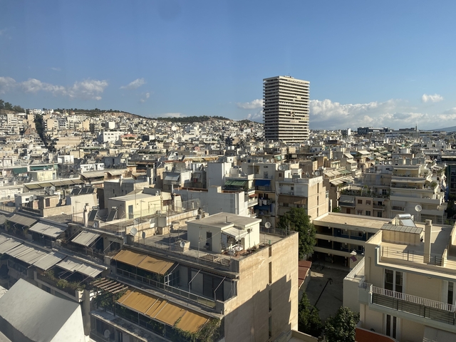 View over a densely built city area with hills in the background.