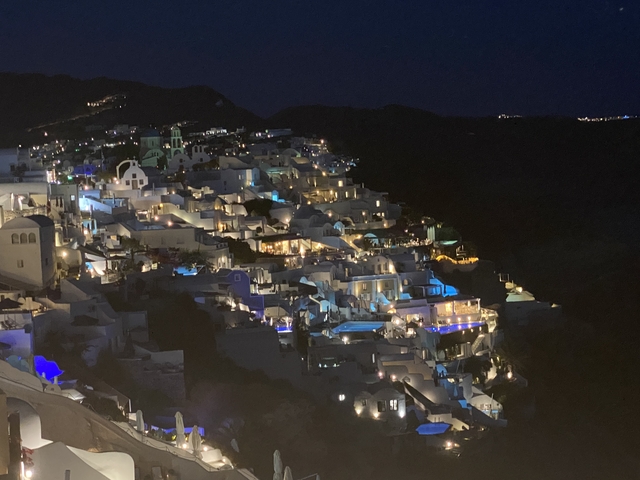 Night view of illuminated cliffside buildings.