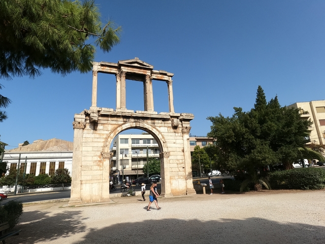Ancient arch structure with people nearby.