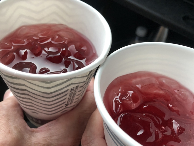 Close-up of two cups filled with a red iced drink.