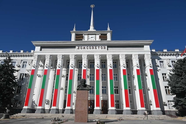       Government building with a statue and flags.
  