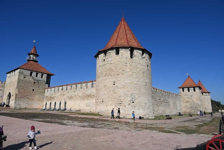       Stone fortress with towers under clear sky.
  