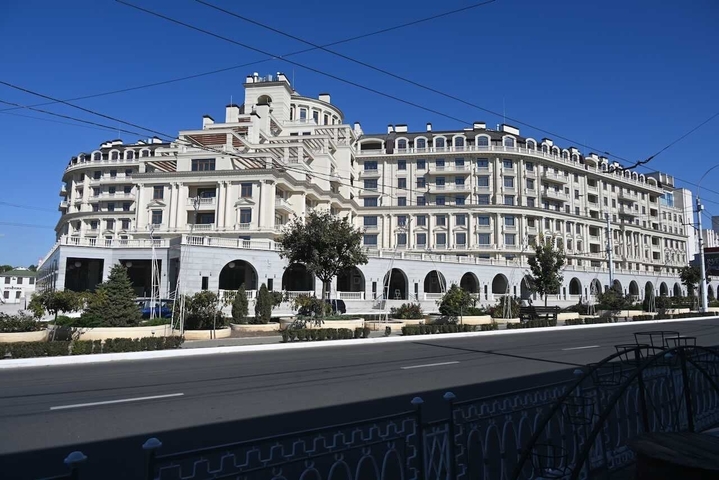      Elegant hotel building with arches and balconies.
  