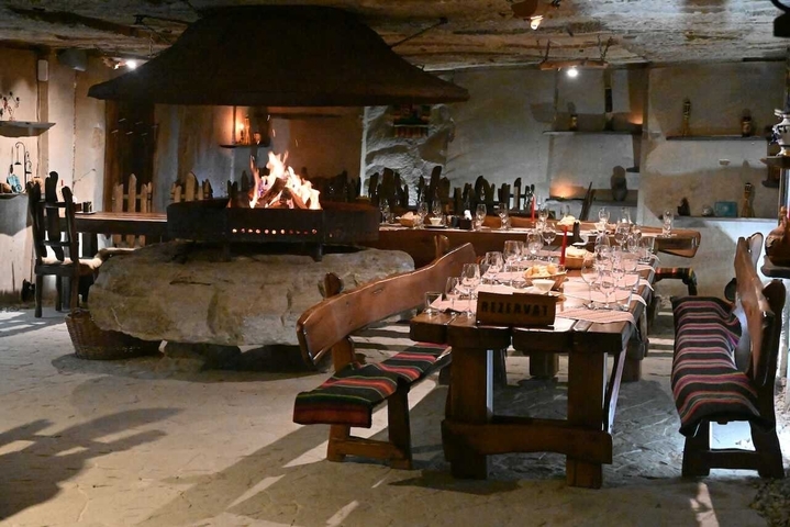       Rustic dining area with a large stone fireplace.
  