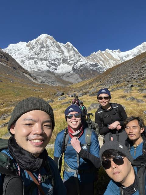       Hikers posing with snowy mountains in the background.
  