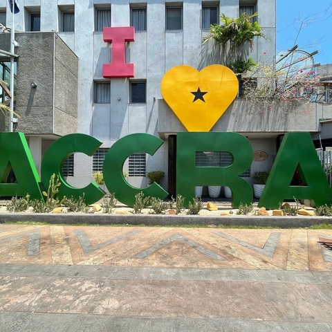       Large sign spelling 'ACCRA' in front of a building.
  