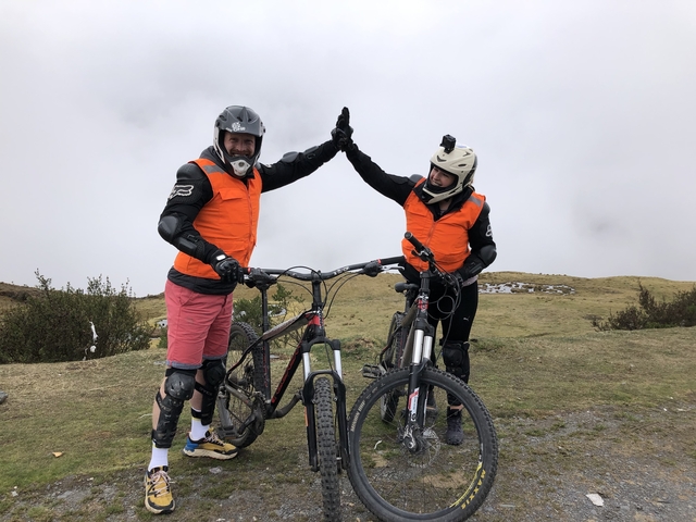       Two cyclists in protective gear giving a high-five.
  